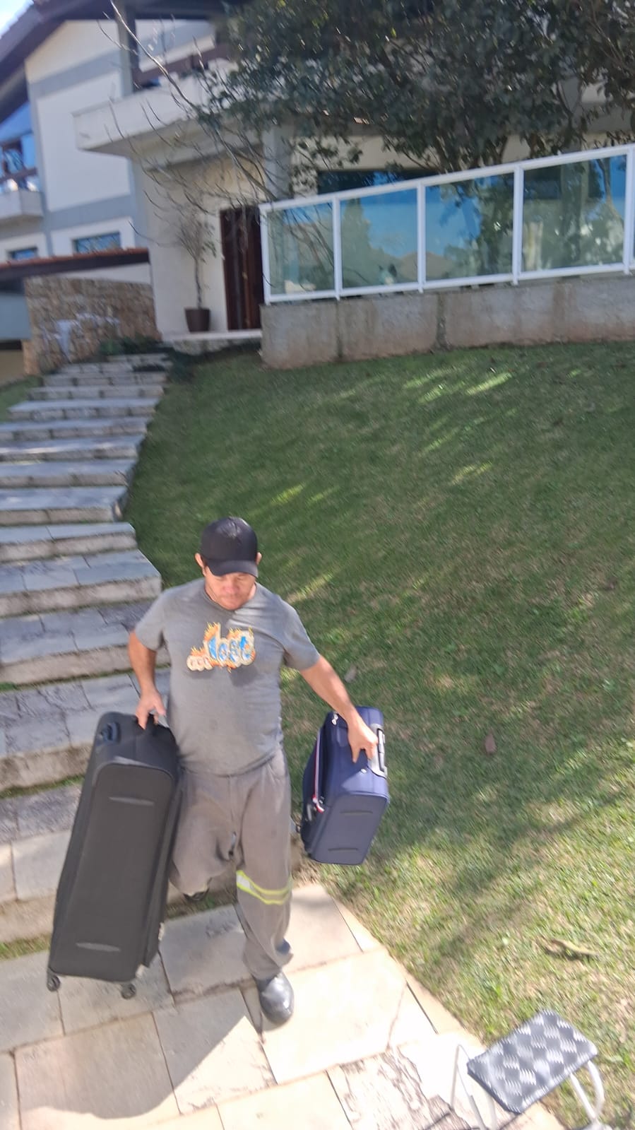 Profissional carregando malas em escadaria externa